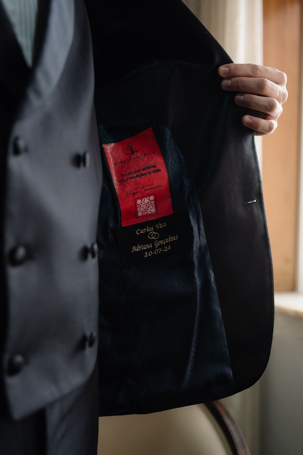Close-up view of a black suit jacket pocket with a red event pass or ticket visible.