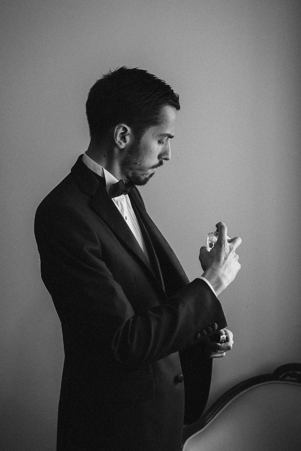 Black and white profile shots of a person in formal attire adjusting their cufflinks.