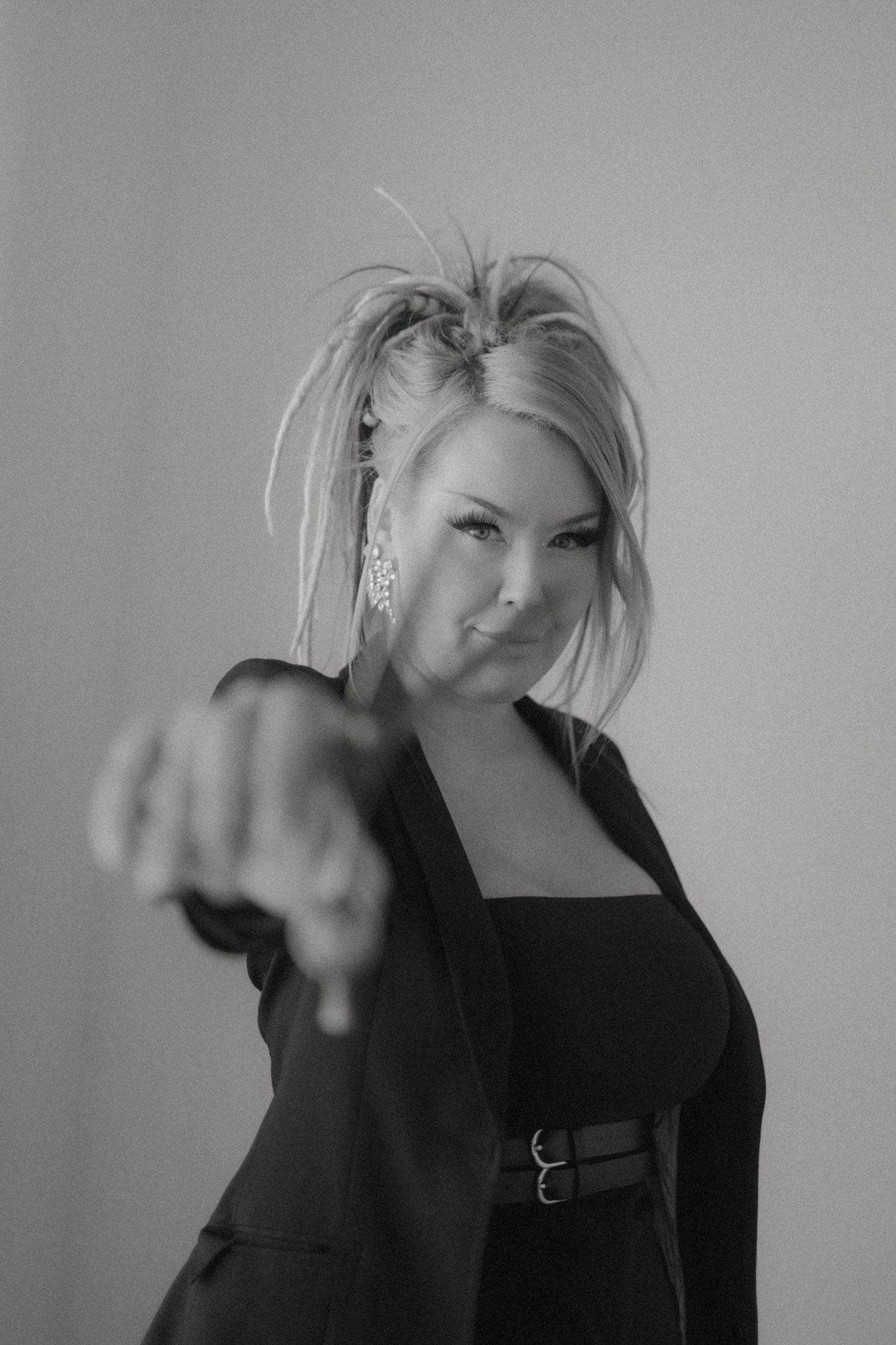 Black and white portrait showing dramatic pose in professional studio setting.