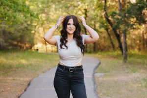 Natural outdoor portrait session with person in casual attire among autumn trees.