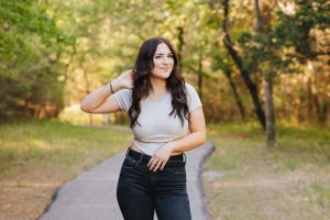 Outdoor portrait session on a wooded path during golden hour with casual outfits and natural lighting.