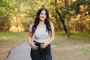 Lifestyle photoshoot on a nature trail with autumn trees in the background.