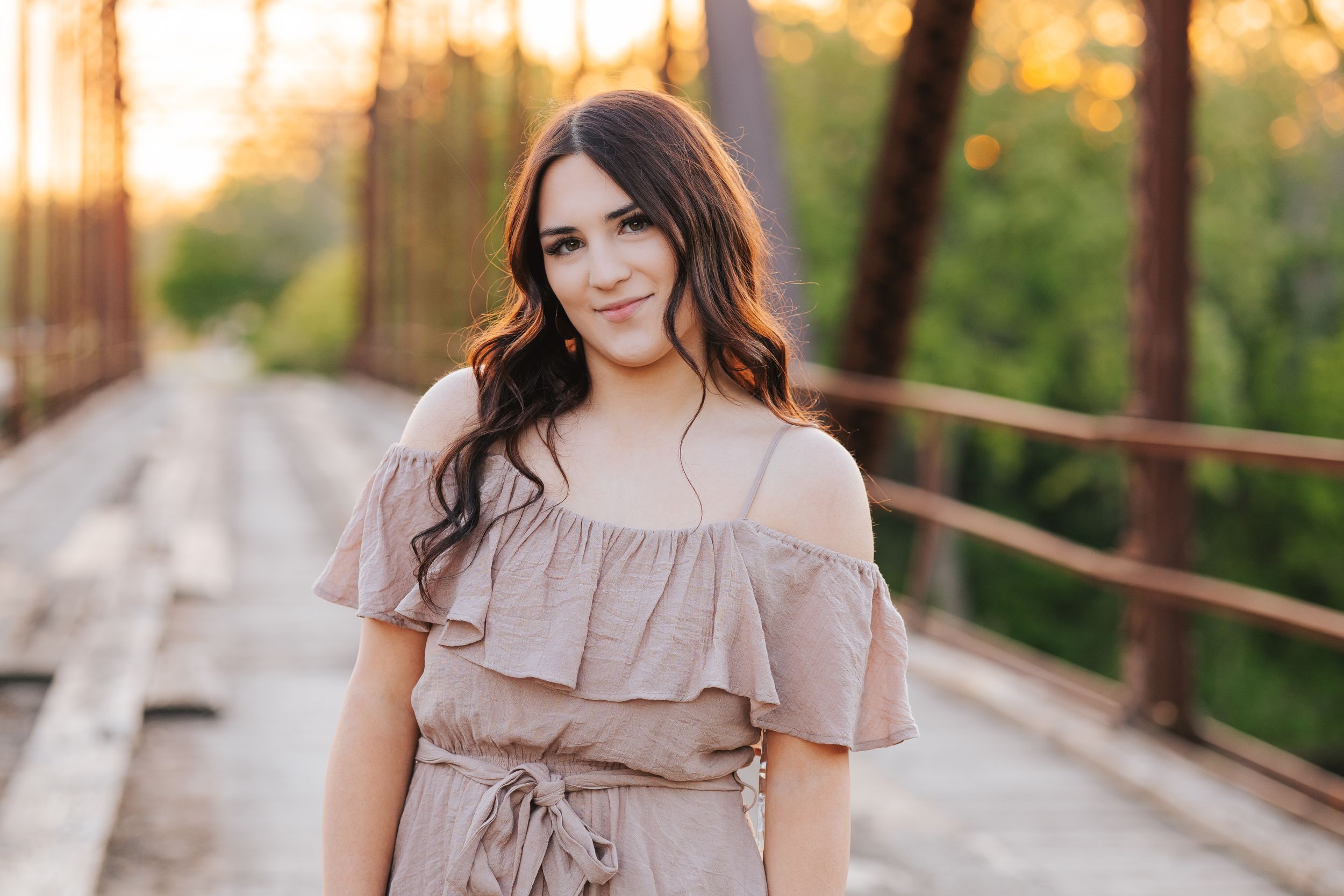 Dreamy portrait session in blush dress against forest backdrop.