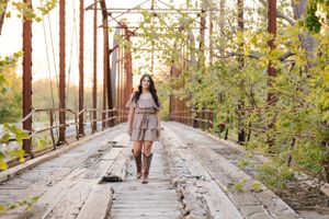 Full length lifestyle portraits on wooden bridge with natural forest scenery.