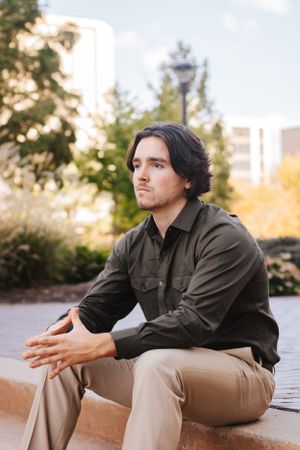 Casual outdoor portraits in khaki pants and dark shirt showing contemplative poses.