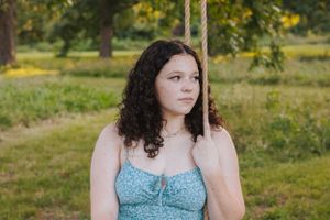 Outdoor portrait series in blue dress surrounded by natural scenery.