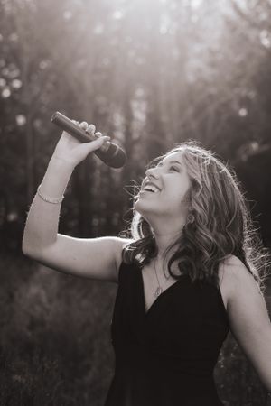 Artistic black and white portrait captures carefree laughter in natural sunlight.