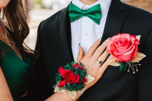 Formal attire details with green bow tie and red rose boutonnieres.