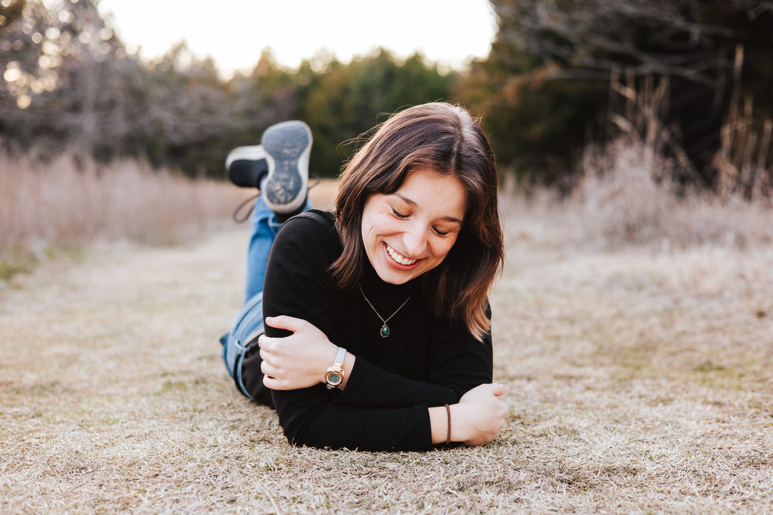 Candid lifestyle photos showing relaxed poses on grassy ground during golden hour.