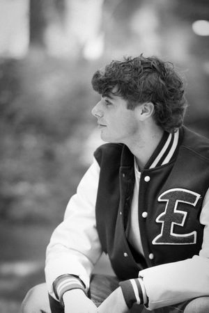 Athletic figure in a black and white varsity jacket shown in profile view.