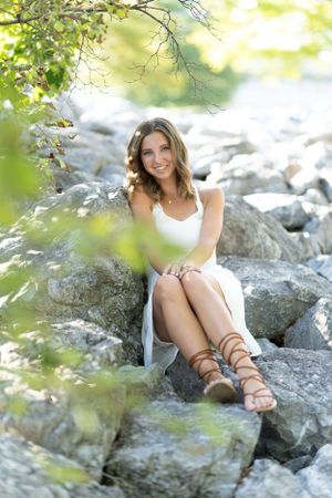 A summer portrait on rocky terrain with greenery and natural lighting.