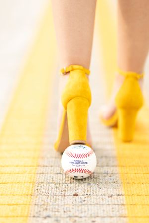 Baseball and yellow shoes walking across a textured surface in sequence.