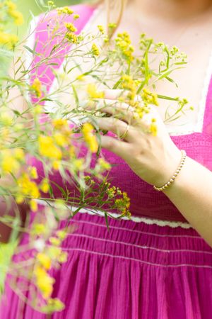 Delicate yellow and pink flowers frame a soft-focused portrait in magenta.