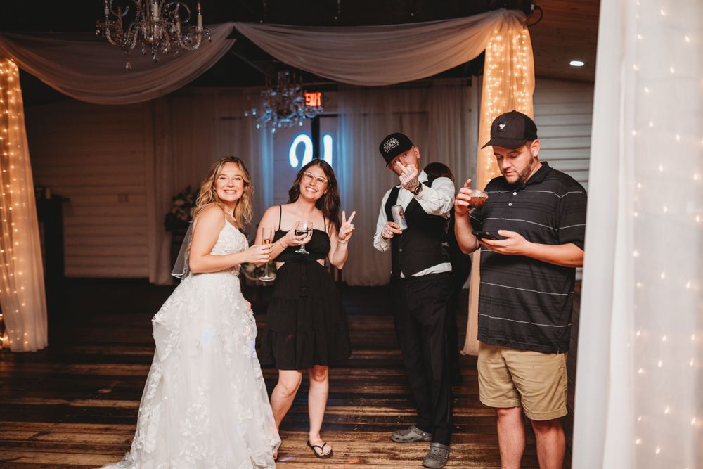 Wedding party members sharing drinks and laughter during reception celebrations.