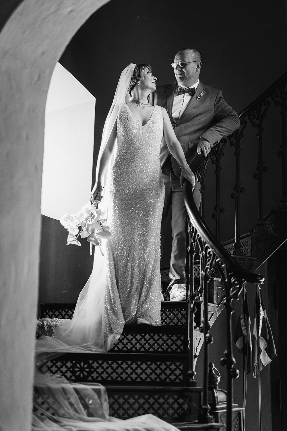 Black and white wedding photography sequence showing bride and groom in dramatic backlit poses on a staircase.