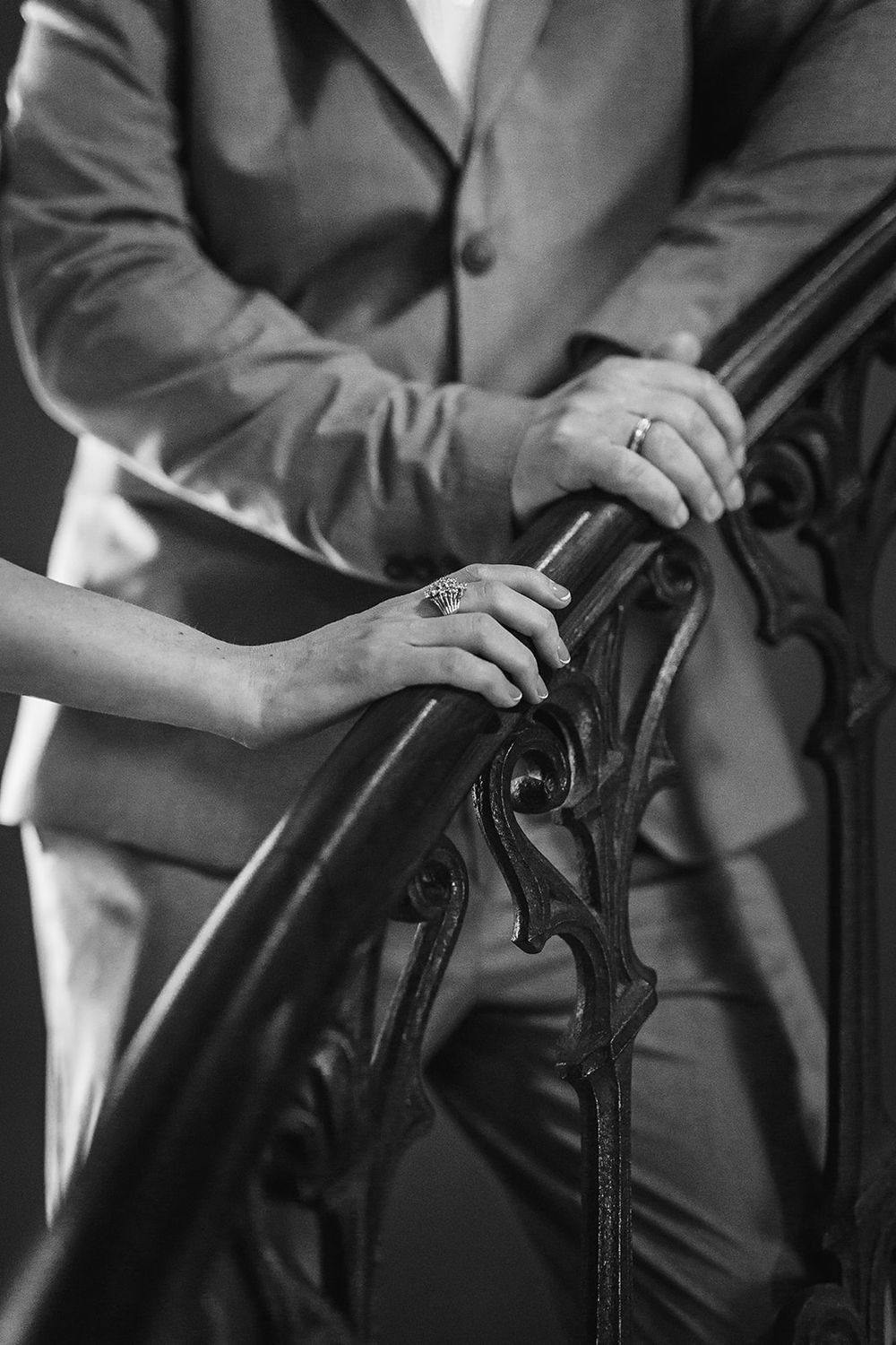 Close-up black and white photo sequence showing hands adjusting an antique wrought iron railing or decorative piece.