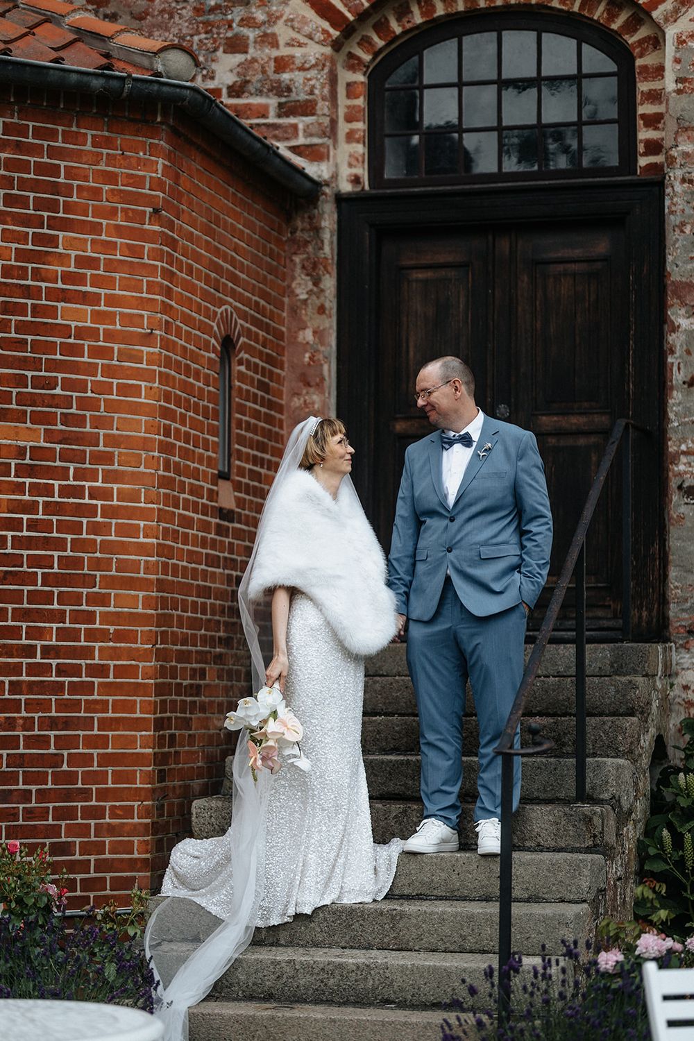 A collection of wedding photos against a rustic brick wall showing romantic moments on stone steps.