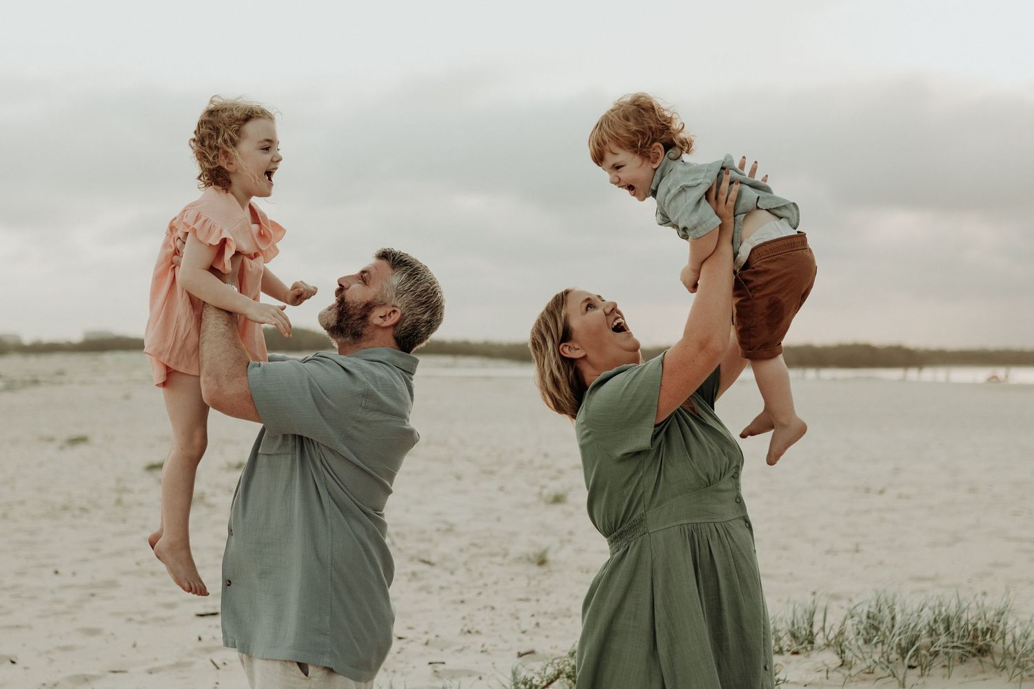 Family portrait session at sunset with coordinating sage green outfits.