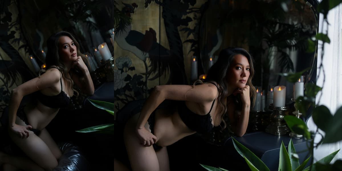 A woman in a dark setting poses with dramatic lighting and greenery in the background.