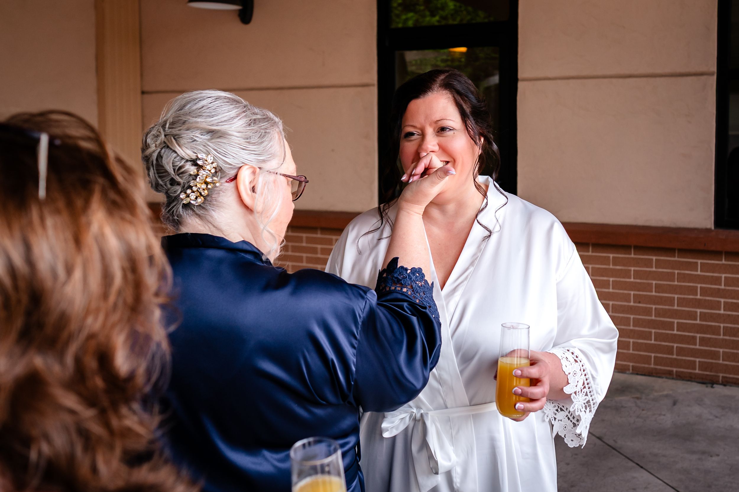 A touching candid moment shared between wedding guests during an outdoor reception.
