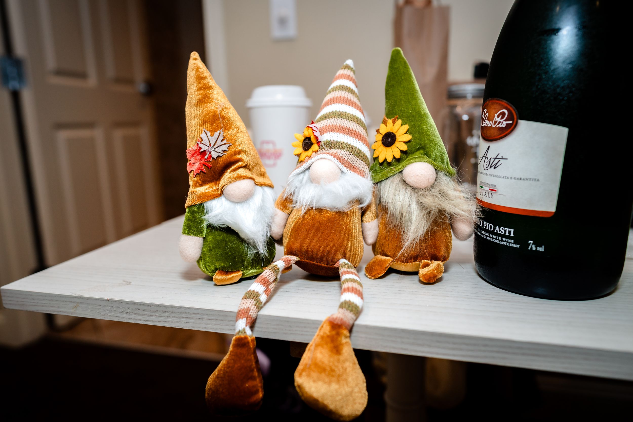 Decorative gnome figurines and holiday ornaments displayed on white shelves.