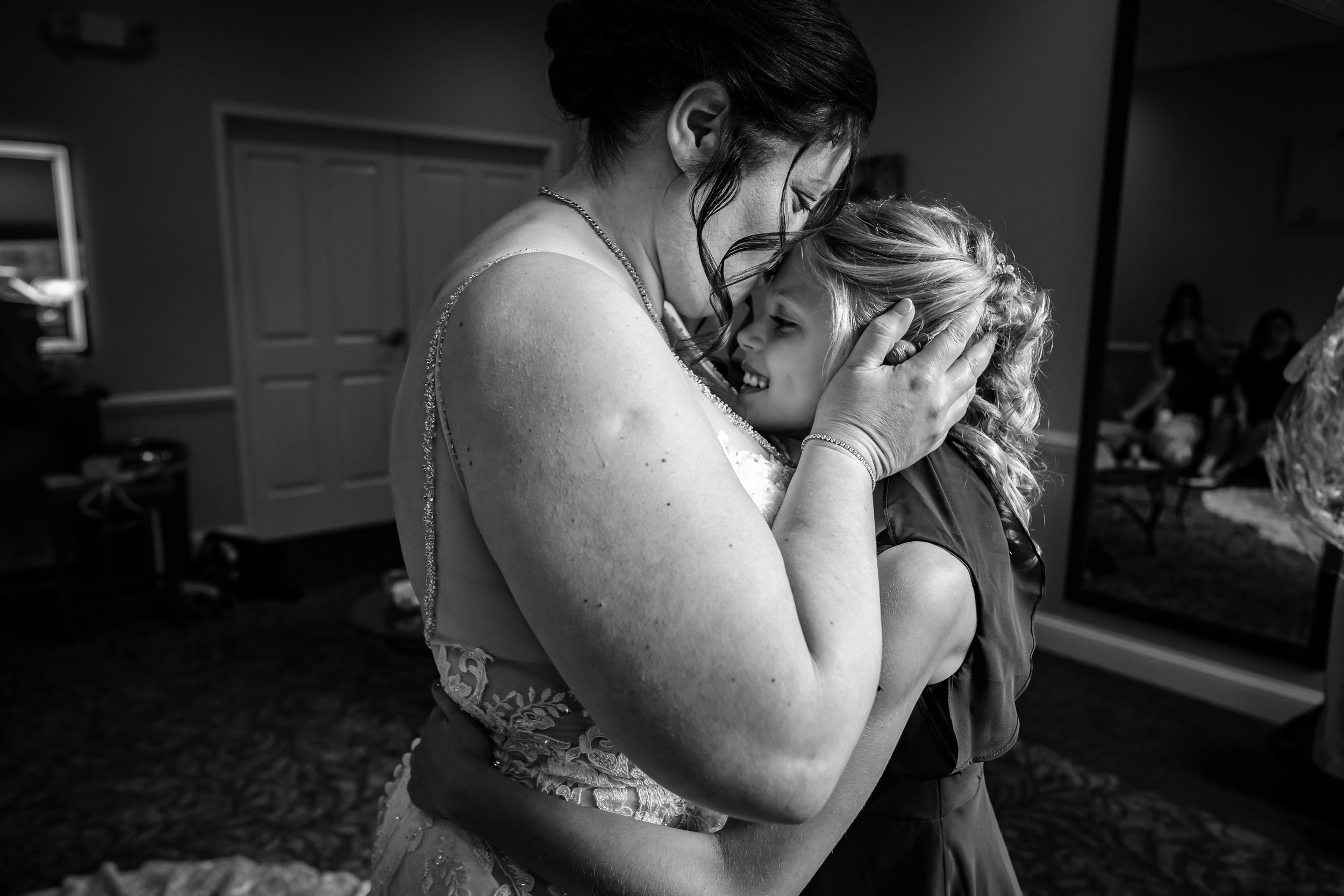 An intimate black and white moment captured during wedding preparations.