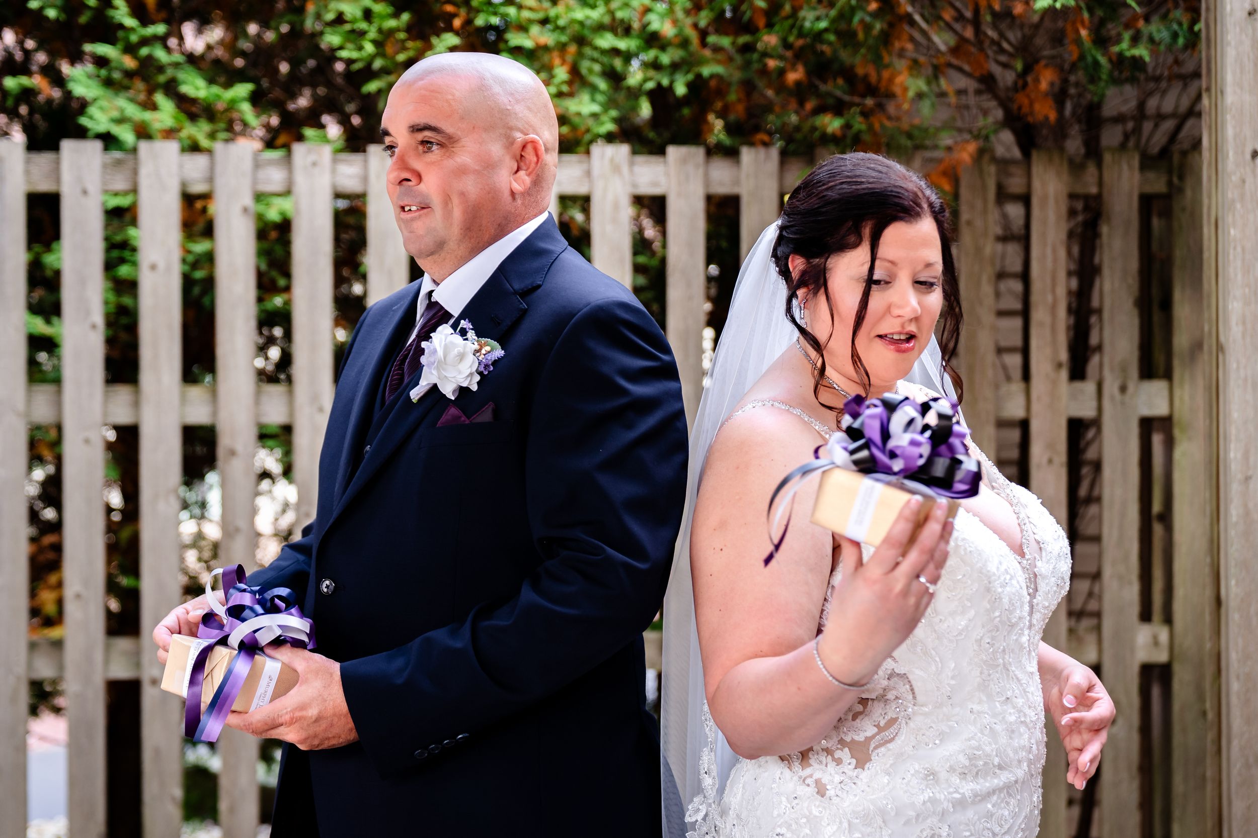 Candid wedding ceremony moments captured under white garden pergola with floral accents.