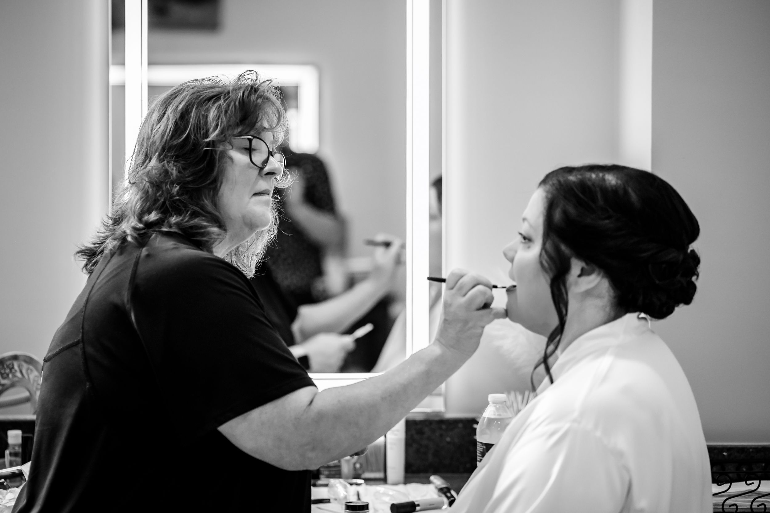 Black and white photos showing wedding day preparations in a dressing room.