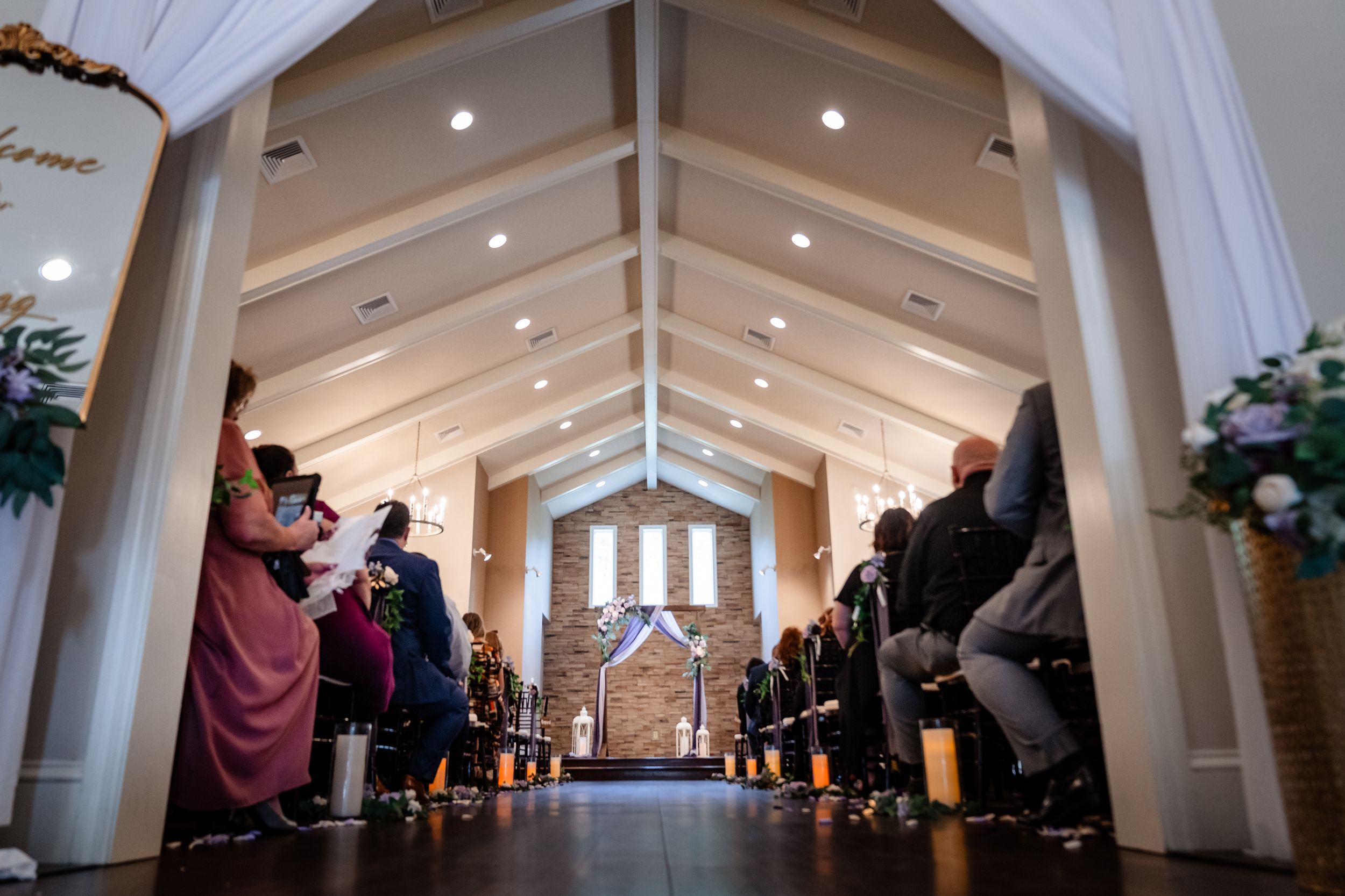 Interior view of elegant wedding chapel with white draped ceiling and rows of seating.