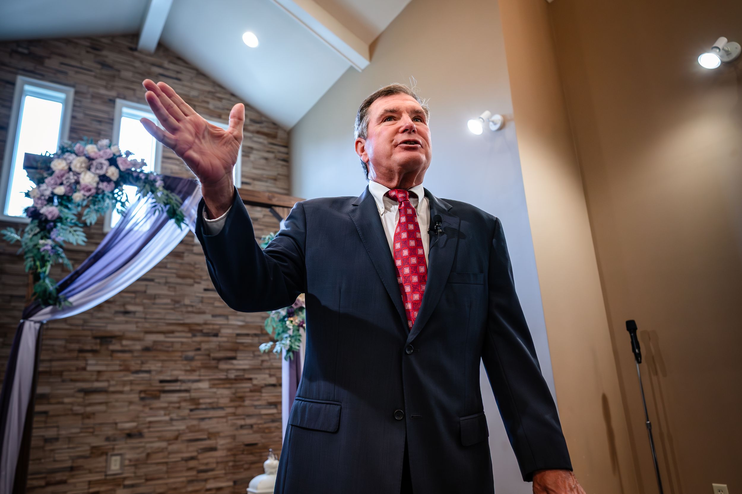 Wedding ceremony candid moments captured inside modern chapel with stone accent walls.
