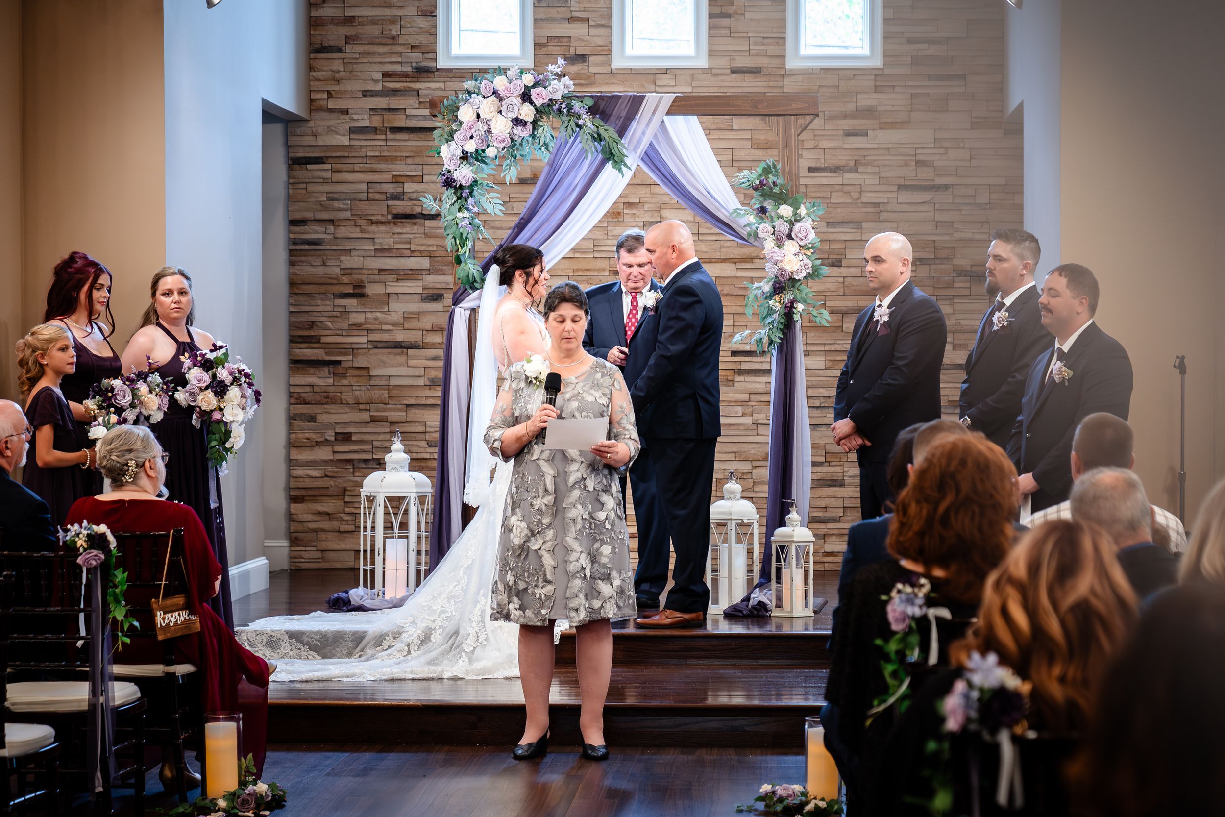 Wedding ceremony in progress inside modern chapel with stone walls and natural lighting.