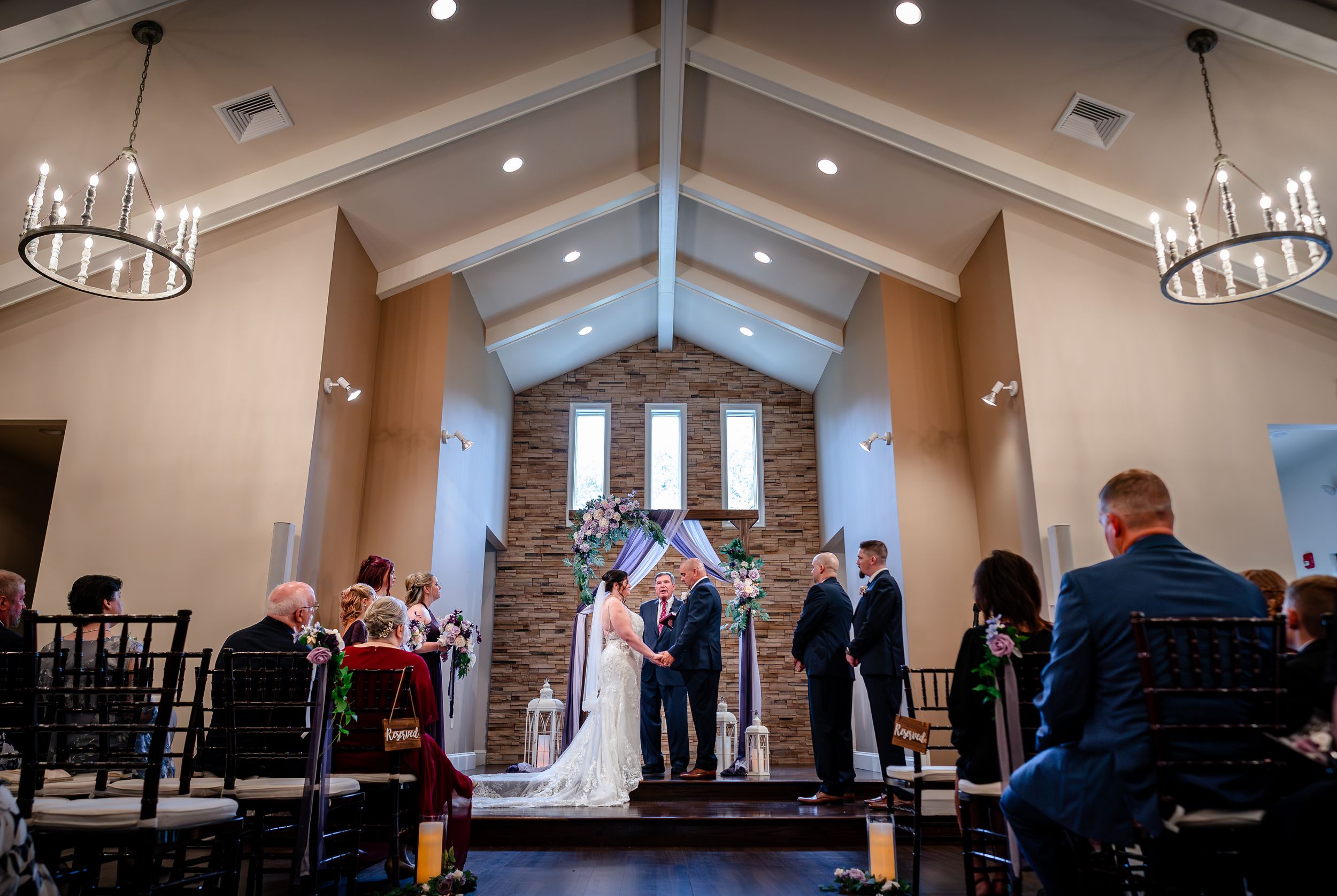 Interior view of wedding ceremony venue with stone accent wall and vaulted ceiling.