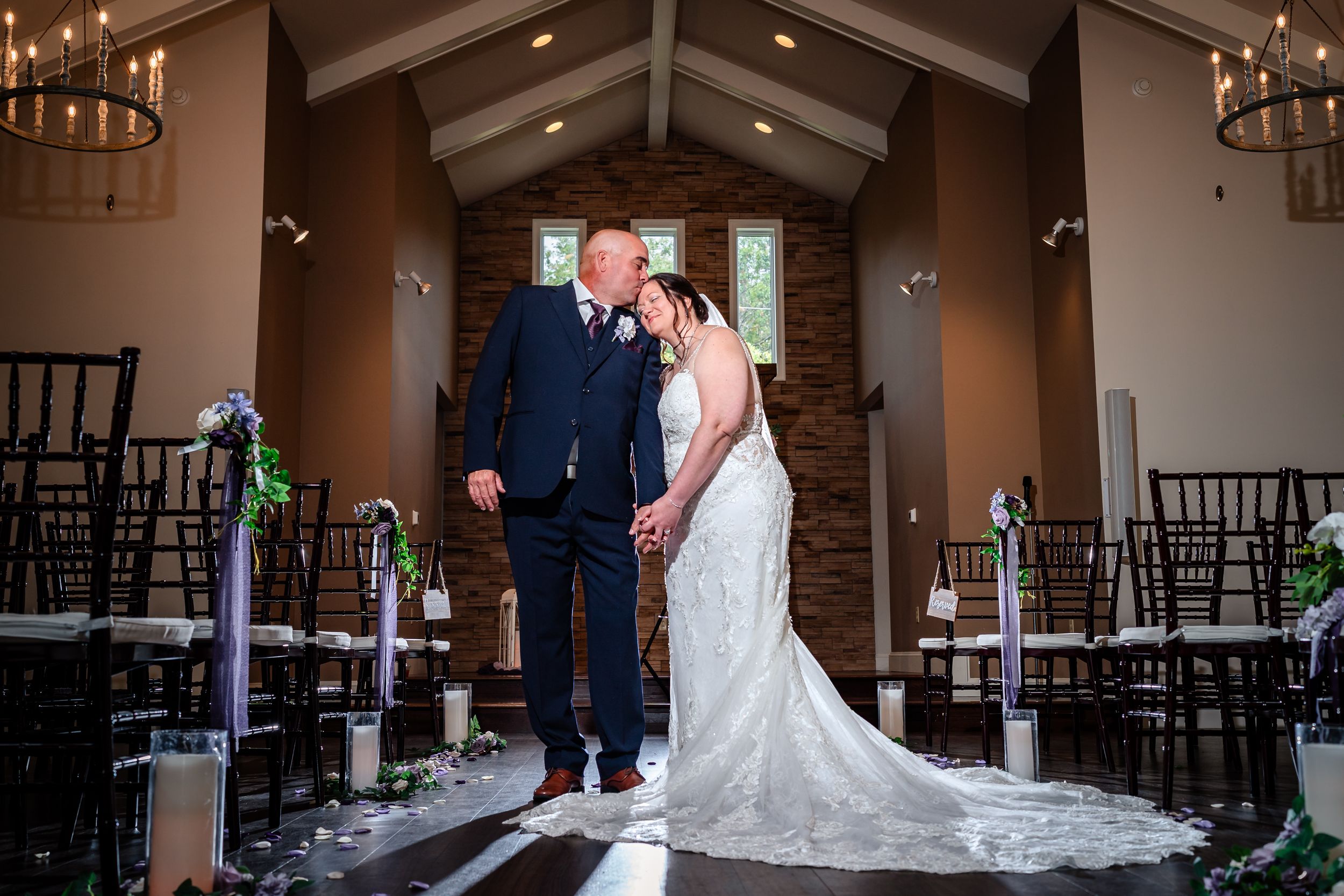 Interior view of a rustic chapel wedding venue with wooden beams and elegant lighting.
