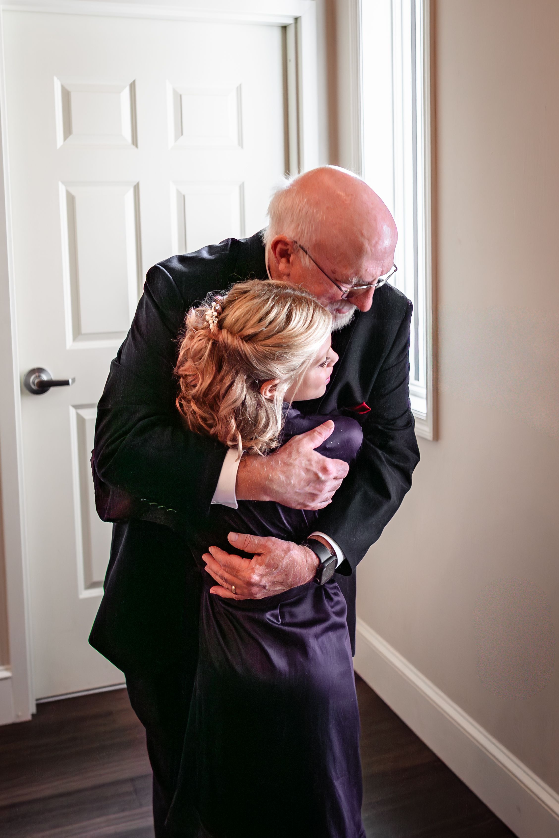 Emotional embrace captured in hallway before wedding ceremony.