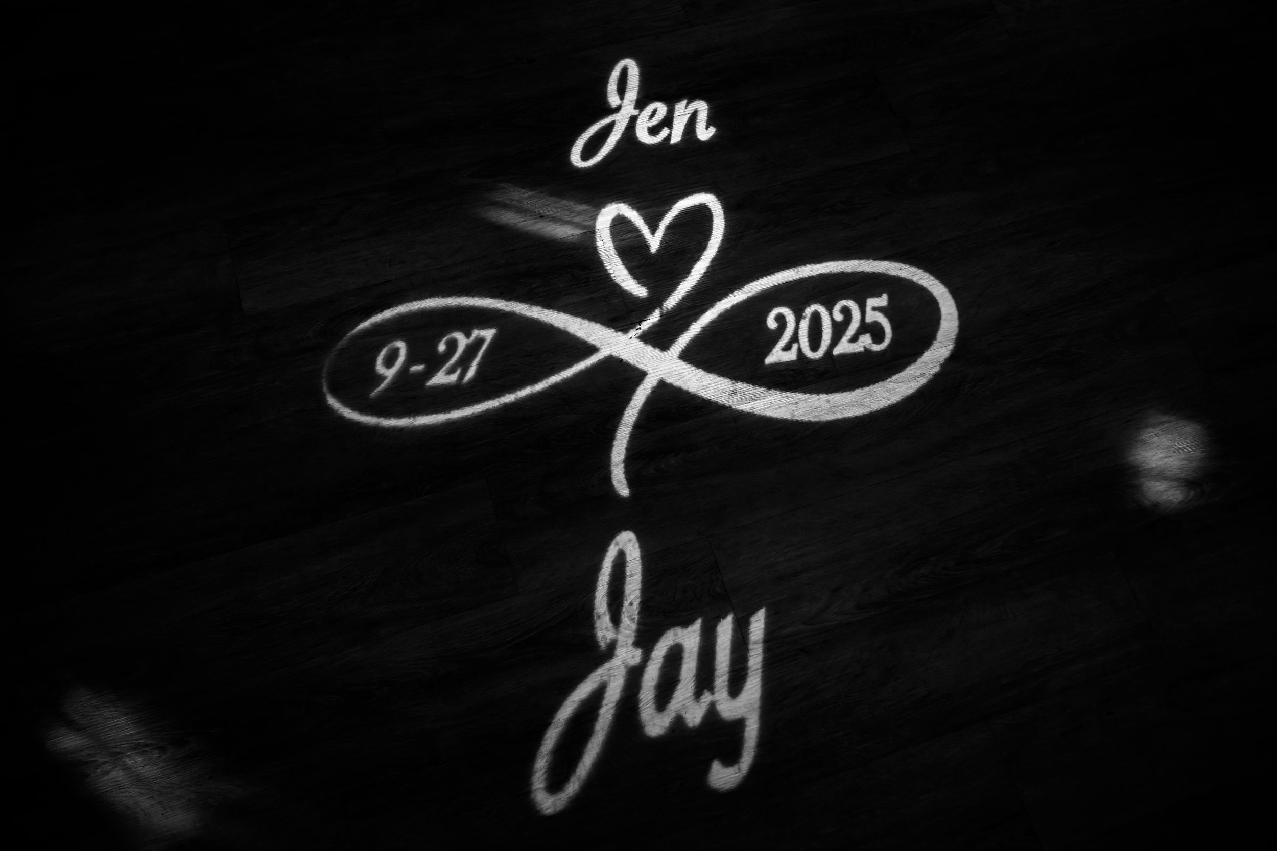Artistic black and white calligraphy text displaying wedding details.