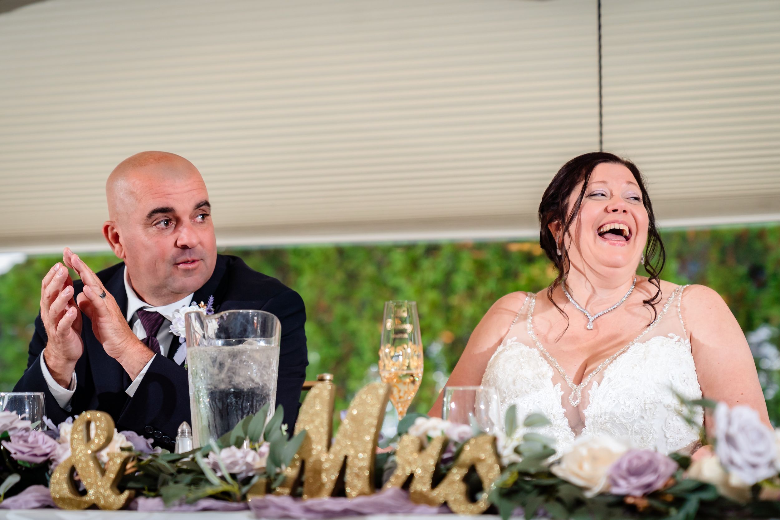 Wedding reception guests enjoying a celebratory toast with champagne glasses raised in an elegant venue.