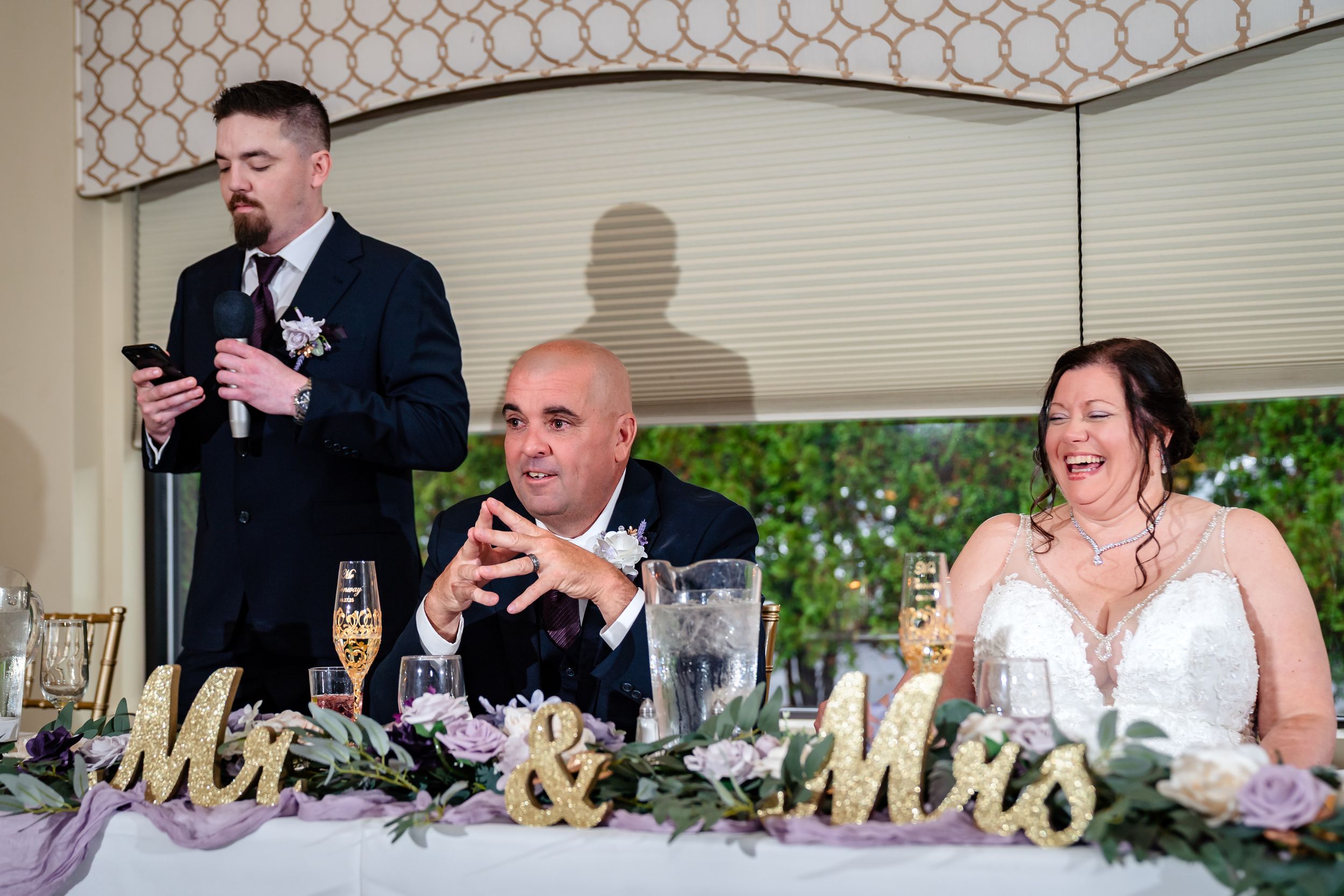 Wedding reception guests making toasts and speeches during dinner celebration.