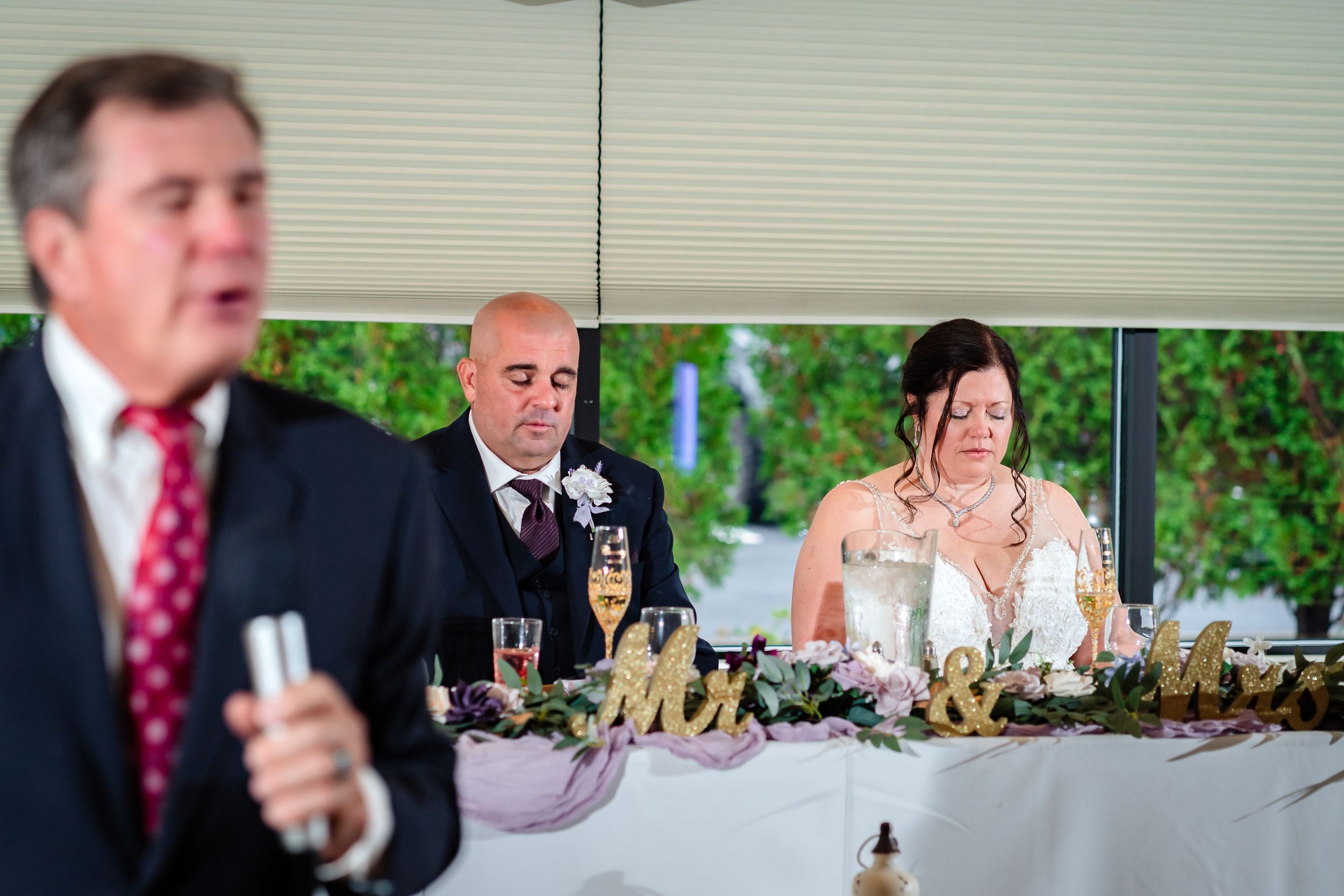 Wedding reception guests raising glasses during emotional speeches and toasts.