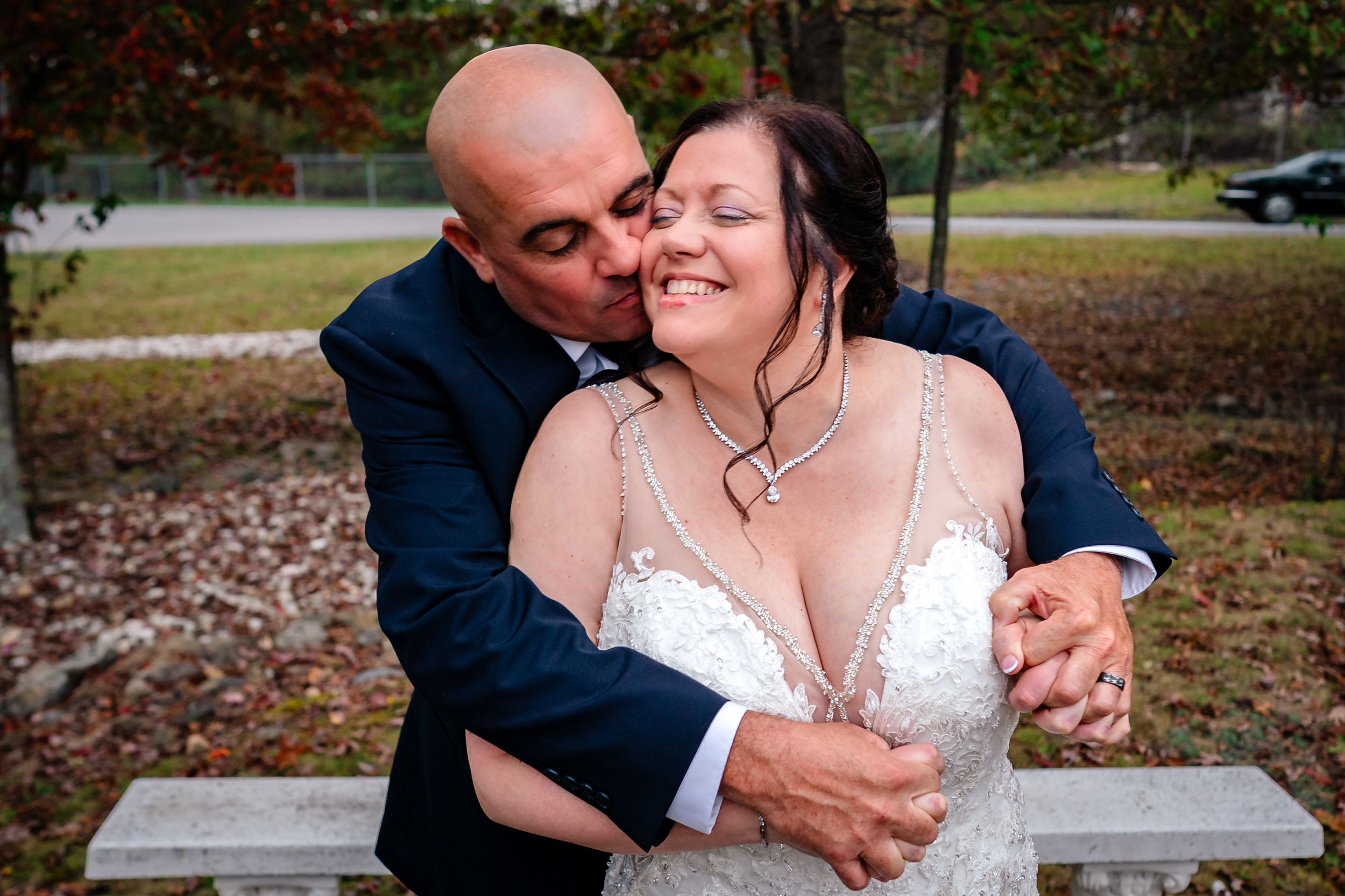 Tender moments between newlyweds during autumn outdoor photo session.