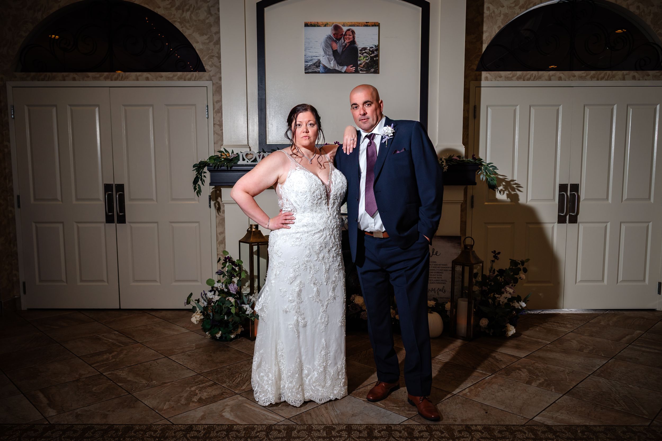Indoor wedding portraits taken in front of white doors with elegant lighting.