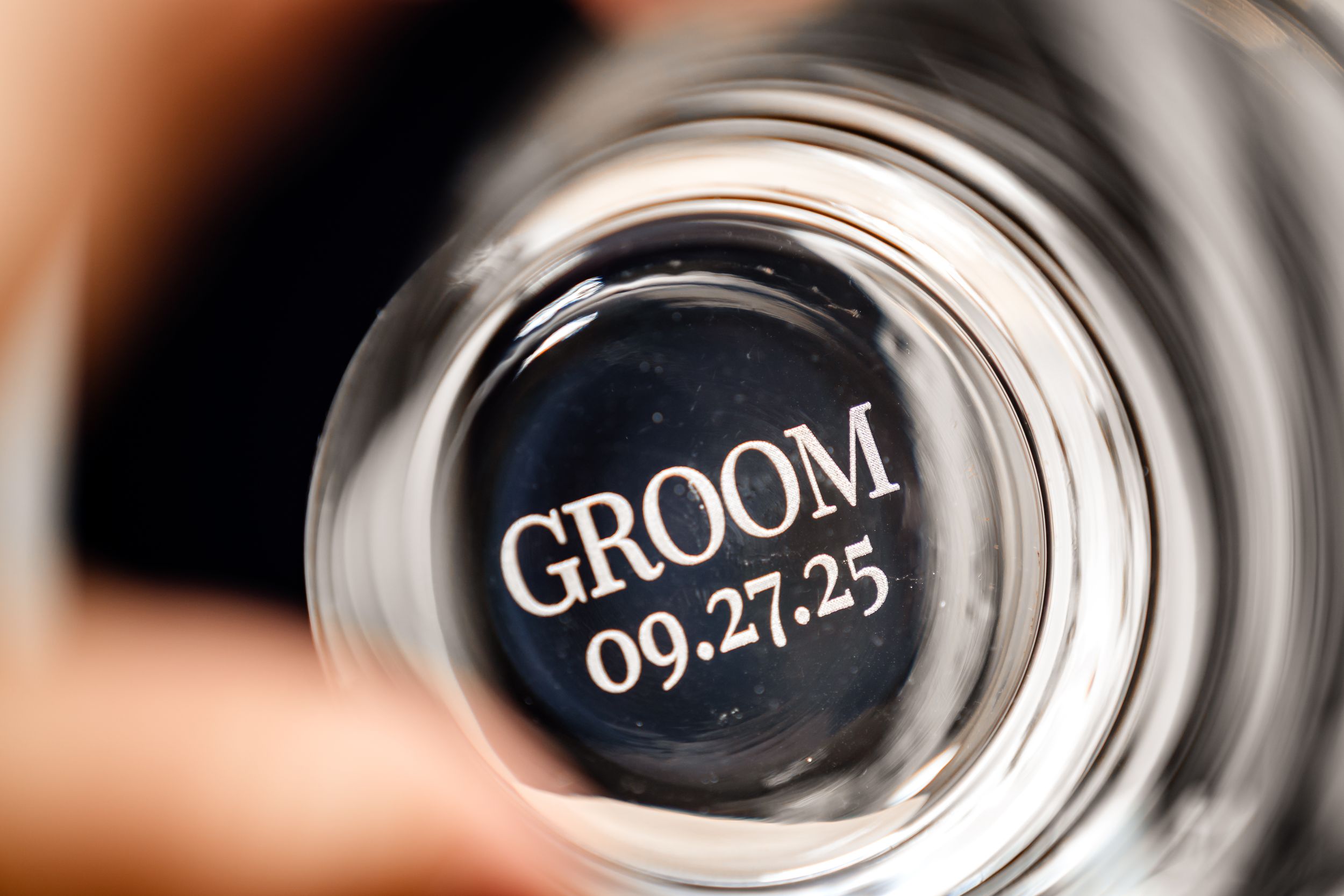 Detail shots of engraved wedding date and text on metallic flask.
