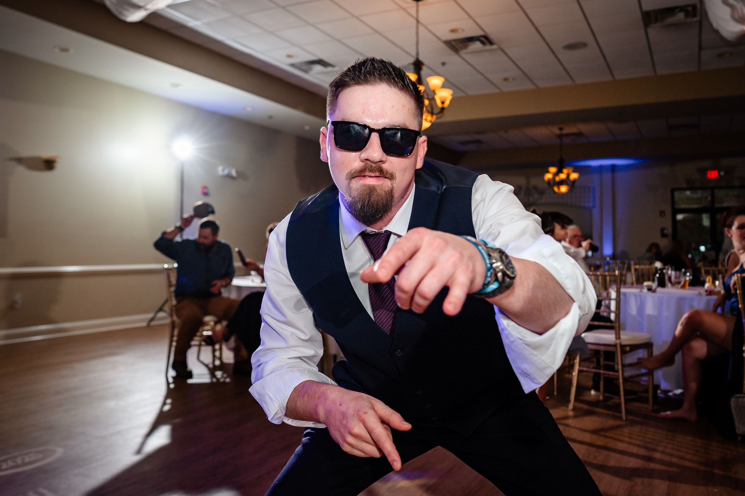 Wedding reception candid shots on dance floor with dramatic lighting effects.