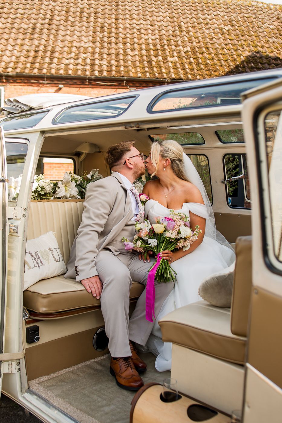 Romantic moment captured inside a vintage cream-colored Volkswagen van.
