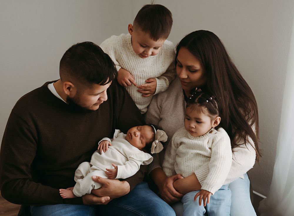 A series of four tender family moments showing parents and children sitting together in casual indoor settings.