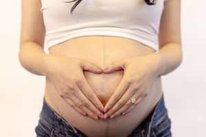 A series of four progressive pregnancy photos showing a growing baby bump against a white background.
