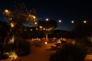 String lights illuminate a cozy outdoor patio setting at night creating a warm ambiance.