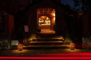 Warm outdoor lighting illuminates a dark pathway with architectural elements.