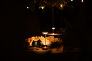 Candlelit outdoor seating area creates an intimate ambiance at night.