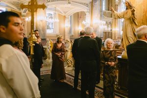Wedding guests and clergy gather in the ornate gilded Basilica of St. Josaphat Catholic church during a formal ceremony.