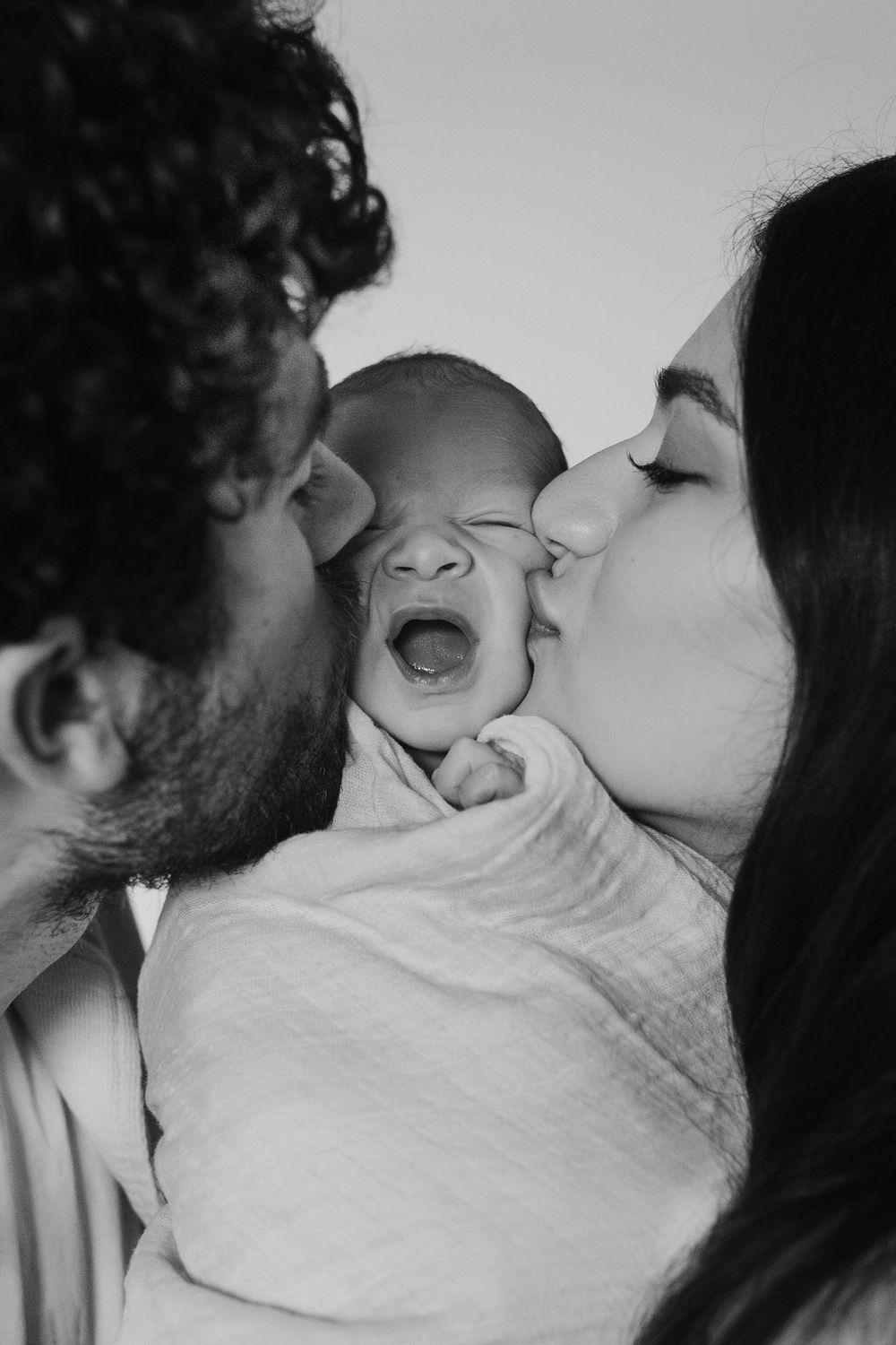 Series of intimate family photos showing tender moments with a newborn baby.